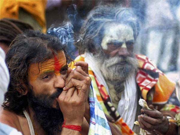 A Naga sadhu smokes a chillum