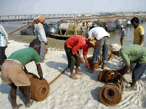 Labourers work to construct a temporary pontoon bridge