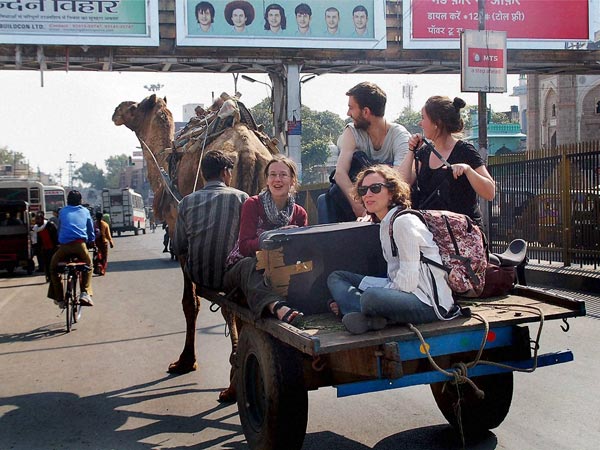 Foreign Tourists travel on a camel cart