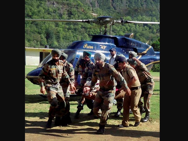 Army personnel carry an injured flood victim
