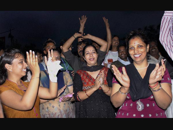 Hindu pilgrims dance and shout religious slogans
