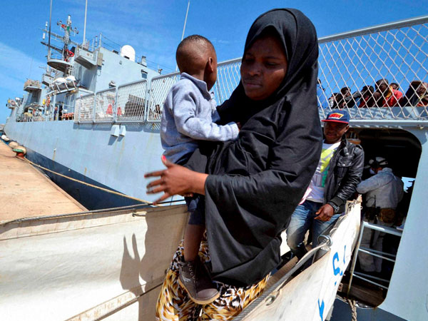Migrants disembark from the Italian Navy ship Sirio