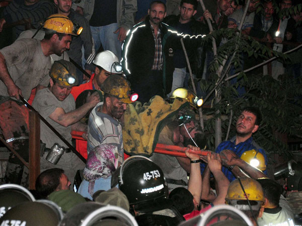 Miners carry a rescued friend after an explosion