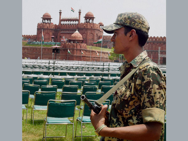 A security person stands guard at the historic Red Fort