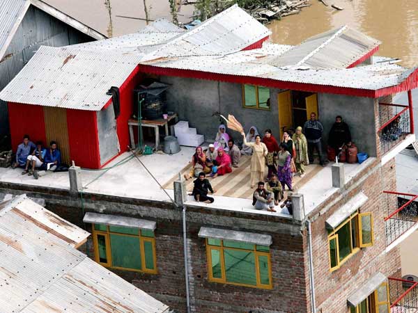 People stranded on a roof signalling IAF personnel