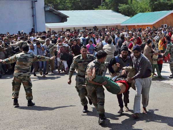 Indian army soldiers carry a seriously ill tourist
