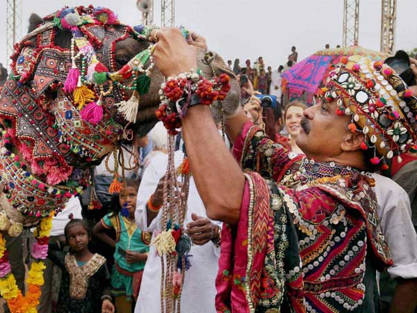 A man, decorating his camel