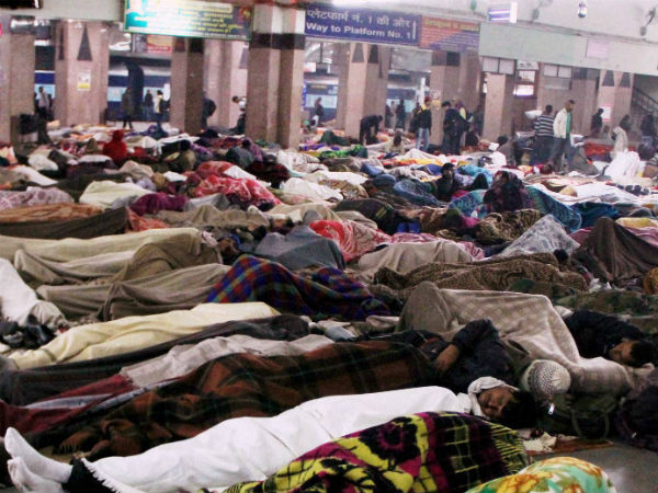 Passengers wrapped in blankets sleep at the Railway station after trains were delayed due to fog during a cold winters night in Allahabad. Passengers wrapped in blankets sleep at the Railway station after trains were delayed due to fog during a cold winters night in Allahabad.