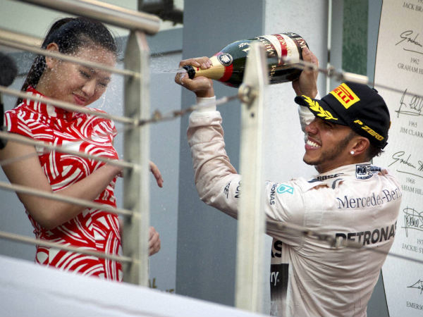 Mercedes driver Lewis Hamilton of Britain sprays champagne on a track attendant on the podium after winning the Chinese Formula One Grand Prix at Shanghai International Circuit in Shanghai Mercedes driver Lewis Hamilton of Britain sprays champagne on a track attendant on the podium after winning the Chinese Formula One Grand Prix at Shanghai International Circuit in Shanghai