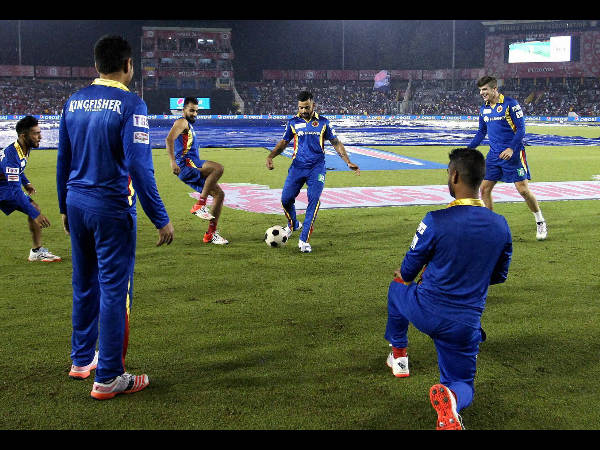RCB captain Virat Kohli and his team-mates play football during a rain break at IPL 2015 RCB captain Virat Kohli and his team-mates play football during a rain break at IPL 2015