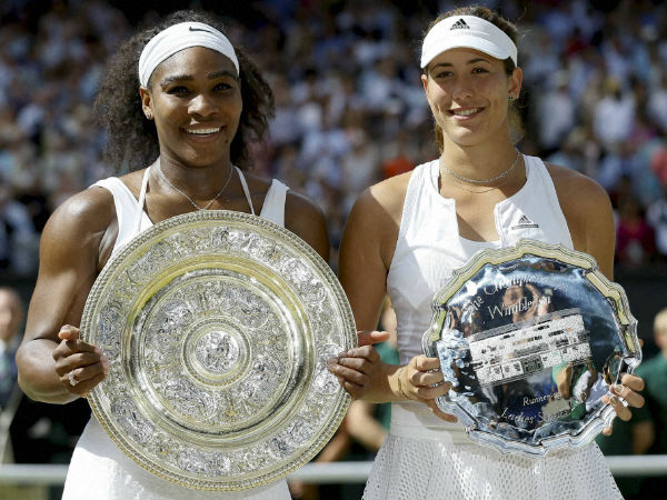Serena Williams, left and Garbine Muguruza hold up their trophies Serena Williams, left and Garbine Muguruza hold up their trophies