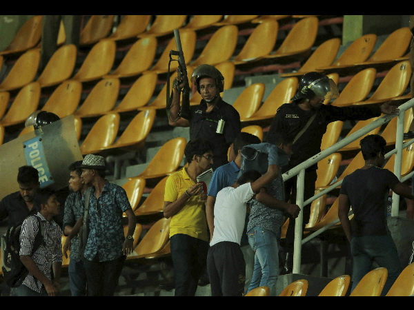 Sri Lankan riot police officers lead spectators out of the stands following a clash Sri Lankan riot police officers lead spectators out of the stands following a clash