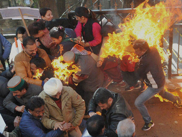 Activists of Congress party try to flee after their clothes caught fire while they were trying to burn an effigy of Prime Minister Narendra Modi during a protest in Shimla on Monday. Activists of Congress party try to flee after their clothes caught fire while they were trying to burn an effigy of Prime Minister Narendra Modi during a protest in Shimla on Monday.
