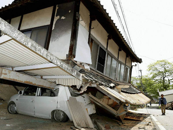 A car sits crushed by a house damaged in Thursday's earthquake in Mashiki, Kumamoto prefecture, southern Japan, Friday, April 15, 2016. A car sits crushed by a house damaged in Thursday's earthquake in Mashiki, Kumamoto prefecture, southern Japan, Friday, April 15, 2016.