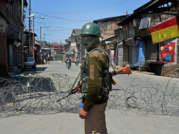 A security jawan stands guard at a street during the second day of strike following the killing of four civilians allegedly in Army and police firing, in Srinagar on Thursday. A security jawan stands guard at a street during the second day of strike following the killing of four civilians allegedly in Army and police firing, in Srinagar on Thursday.