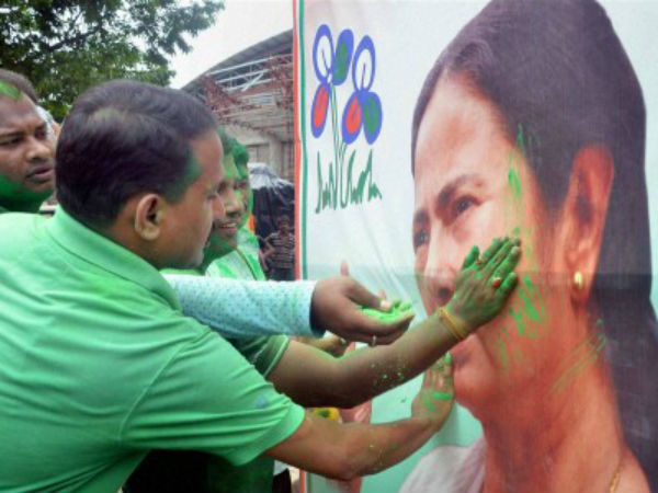 TMC supporters smear color on a poster of Mamata Banerjee in Agartala