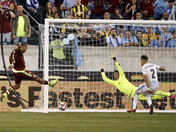 Venezuela's Salomon Rondon (left) scores past Uruguay goalkeeper Fernando Muslera (1) as Jose Gimenez (2) defends during the first half of a Copa America Group C match Venezuela's Salomon Rondon (left) scores past Uruguay goalkeeper Fernando Muslera (1) as Jose Gimenez (2) defends during the first half of a Copa America Group C match