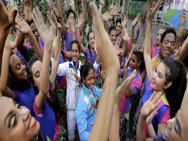Indian field hockey players Deepika Deepika (center right) and Preety Dubey (center left) dance with performers after a welcome ceremony at the Olympic athletes village in Rio de Janeiro Indian field hockey players Deepika Deepika (center right) and Preety Dubey (center left) dance with performers after a welcome ceremony at the Olympic athletes village in Rio de Janeiro