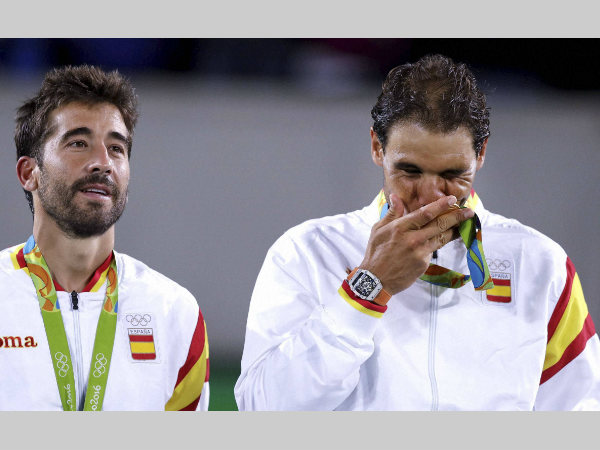 Rafael Nadal, right, kisses his gold medal while standing with partner Marc Lopez, after winning the men's doubles Rafael Nadal, right, kisses his gold medal while standing with partner Marc Lopez, after winning the men's doubles