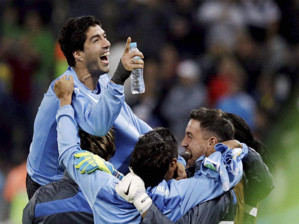 Luis Suarez (top) celebrates with his Uruguayan team mates Luis Suarez (top) celebrates with his Uruguayan team mates