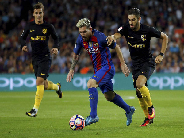 Lionel Messi (center) duels for the ball against Atletico Madrid Lionel Messi (center) duels for the ball against Atletico Madrid
