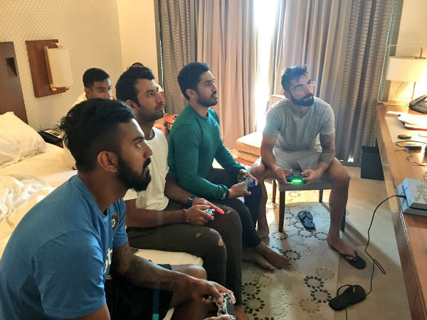 Cricketers playing video game at hotel