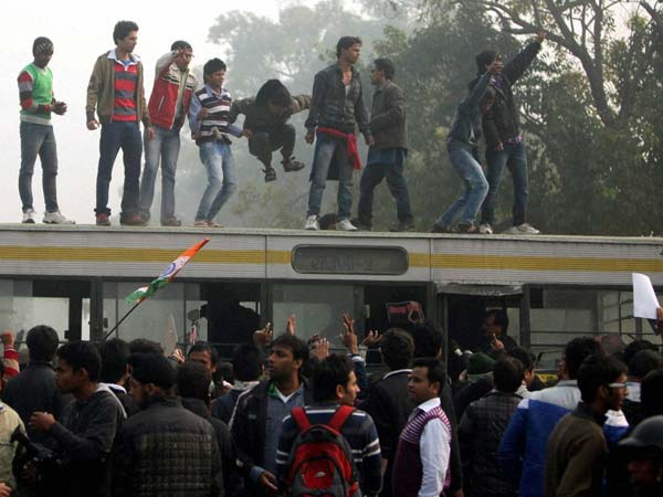 People stand on top of a police vehicle