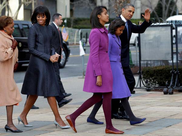 Barack Obama waves as he walks with his daughters Sasha and Malia