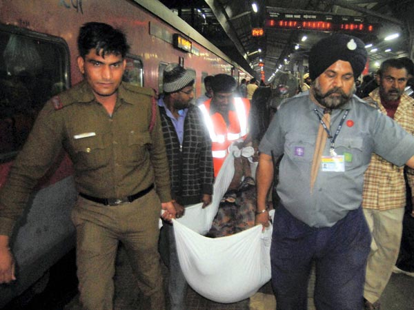 Policeman and rescuers carry body of victim