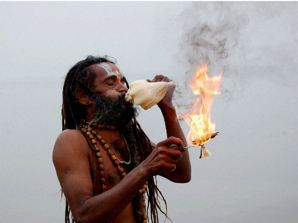An sadhu performs arti after taking holy dip in river Ganga An sadhu performs arti after taking holy dip in river Ganga