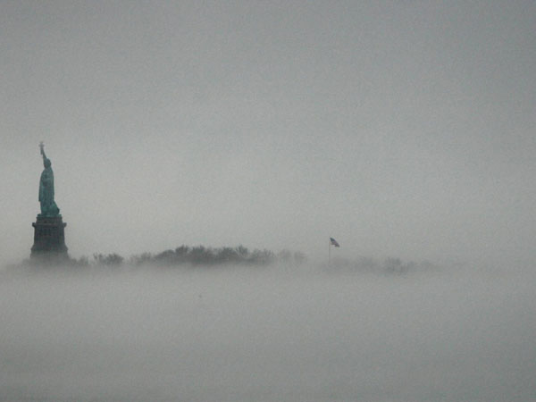New York : The Statue of Liberty stands above the fog on Liberty Island in New York, Saturday, Jan. 11, 2014. The National Weather Service issued flood watches for this weekend from Buffalo to New York City as temperatures rose to over fifty degrees Fahrenheit just days after some upstate areas received up to five feet of snow. 
