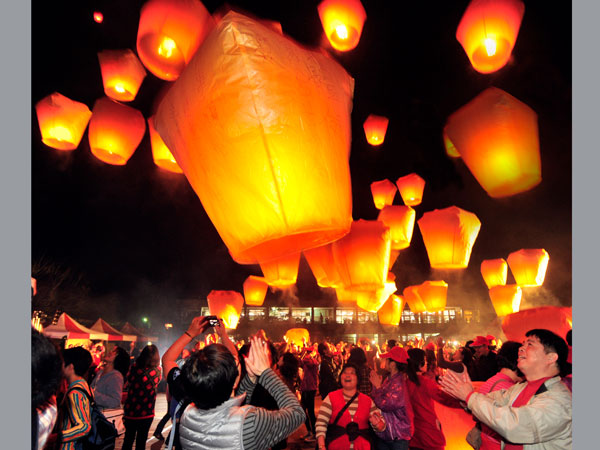 People light sky lanterns