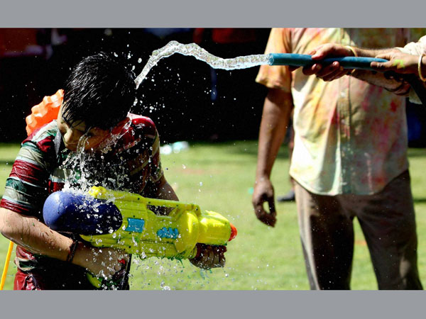 A boy play with water during Holi celebrations A boy play with water during Holi celebrations