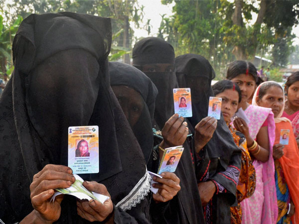 Voters show their voter ID cards outside a polling booth
