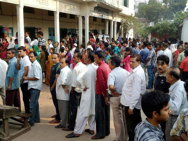 People wait in queues to cast their vote at polling booth