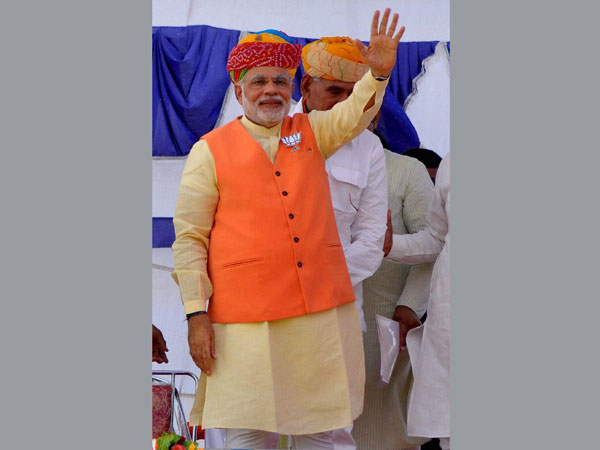 arendra Modi waves to supporters during an election rally