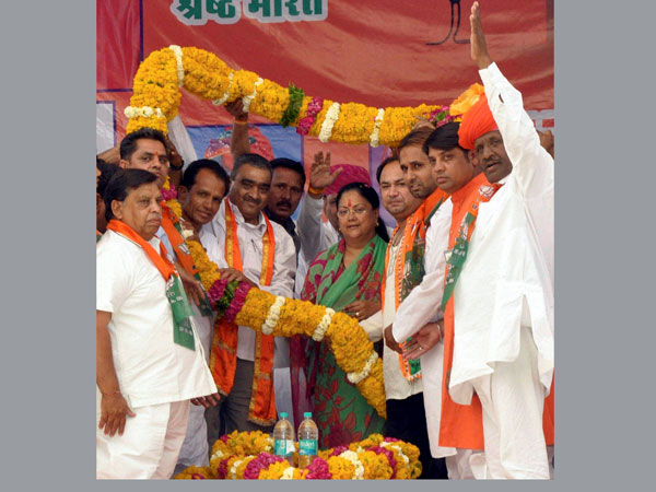 Vasundhara Raje & BJP candidate Hariom Singh being garlanded at an election rally