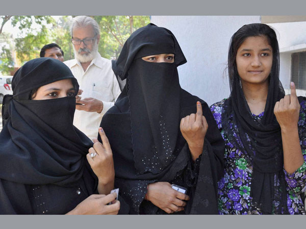 Muslim women show their ink-marked fingers