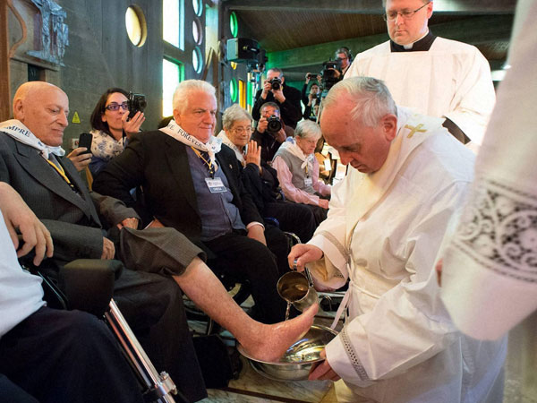 Pope Francis washes the foot of a man