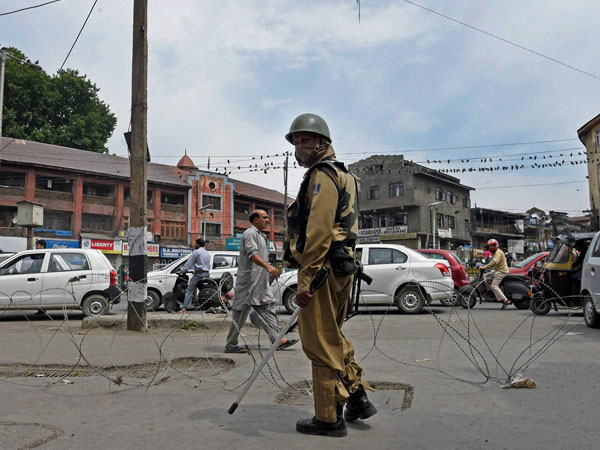 A security jawan patrols during a strike call given by JKLF