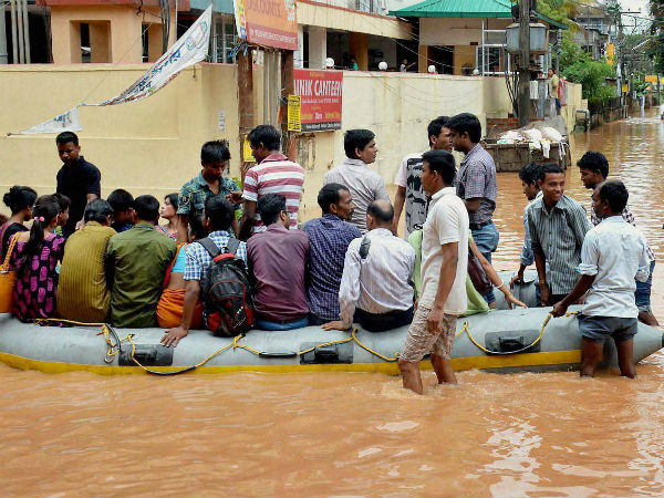 People use rubber boats provided by the district administration to commute in the waterlogged Rajgarh area after heavy rains in Guwahati on Friday. (PTI photo)