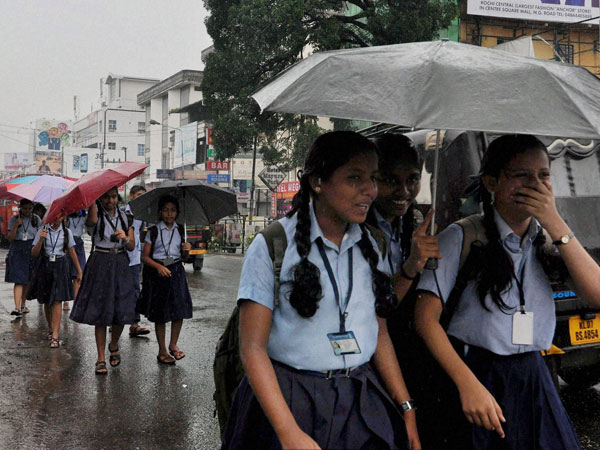 School girls walking under umbrellas as its rains School girls walking under umbrellas as its rains
