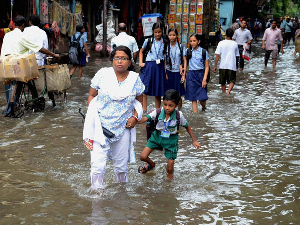 People wade through a water logged street People wade through a water logged street