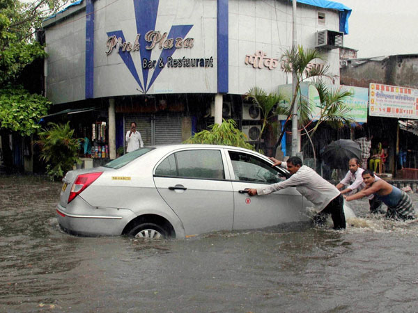People pushing a vehicle stuck at a waterlogged road People pushing a vehicle stuck at a waterlogged road