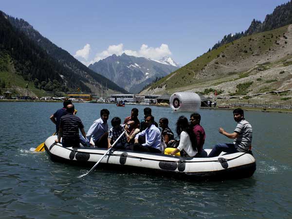 Tourists enjoy themselves aboard a raft on a spectacular blue water lake