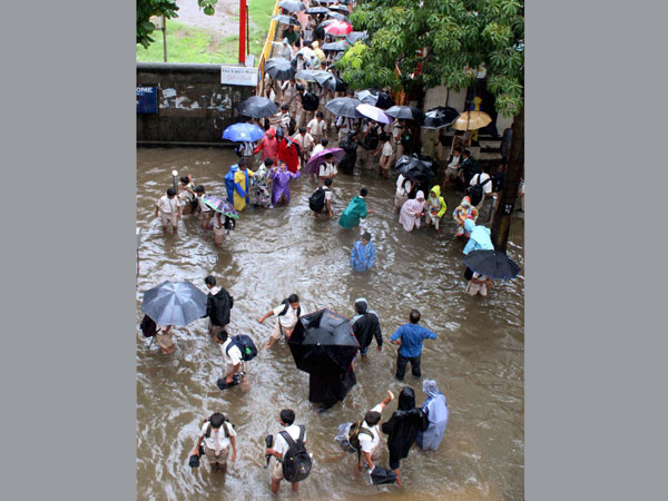 School children wading through a waterlogged street