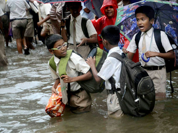 School children wading through a waterlogged street