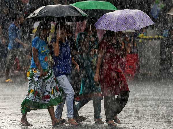 Young walk with umbrellas as it rains in Kolkata
