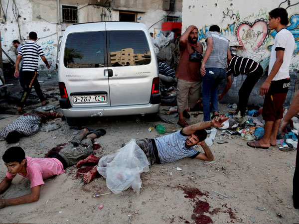 Injured Palestinian men lay on the ground following an Israeli Strike Injured Palestinian men lay on the ground following an Israeli Strike