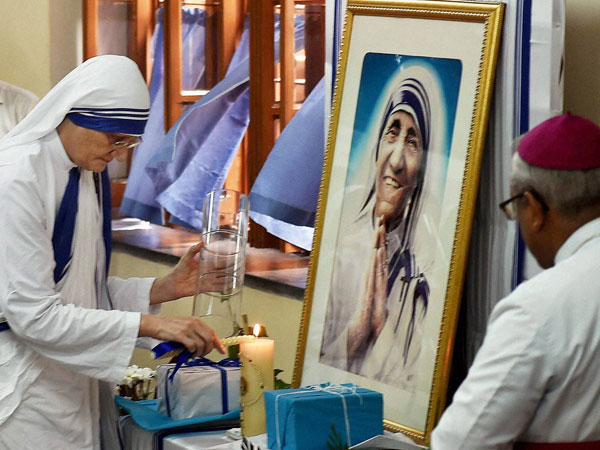 Lights a lamp in front of a portrait Mother Teresa on her death anniversary